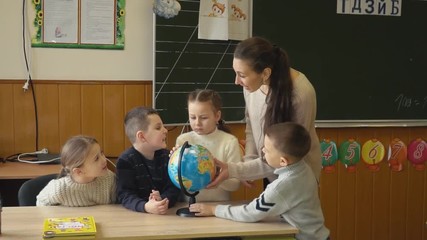 the teacher teaches children using the globe
