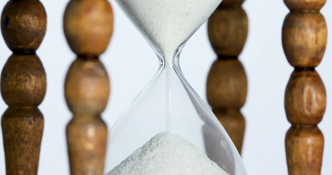 Sand falls quickly through an hourglass.
