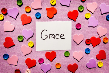 Grace - word on colorful pink background with hearts decorations, religion and mercy concept