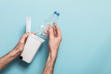 Recycle plastic bottles. Hands putting bottle into a bin