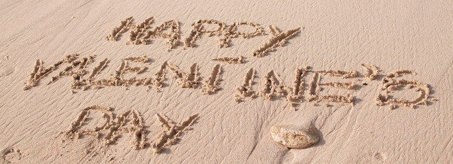 Happy valentine's day text written on the sand