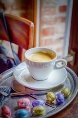 Happy Easter. Cup of coffee espresso and colorful chocolate eggs