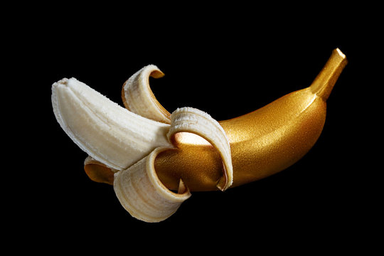 Golden banana on a black background. A modern creative concep with fruit
