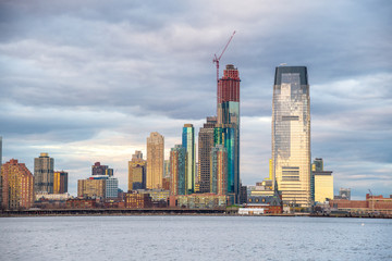 Obraz premium Sunset view of Manhattan skyline from city river, New York City