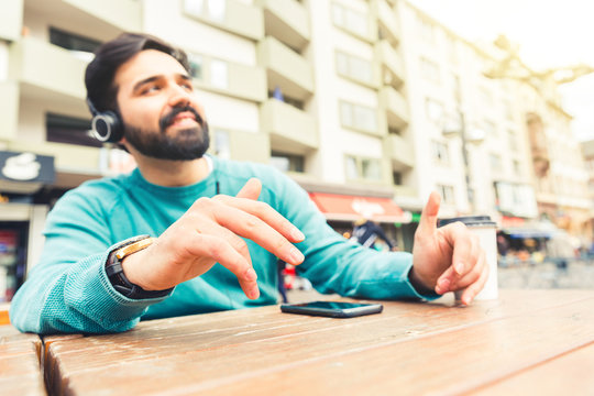 Man listening to music with headphones and dancing with hands