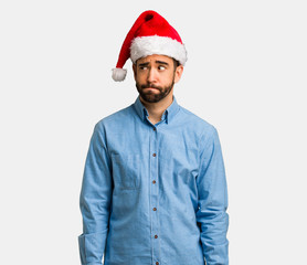 Young man wearing santa hat thinking about an idea