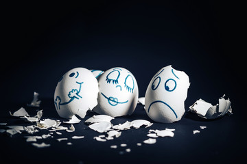 Egg face, broken shell. A sad broken egg looks at the couple in love.