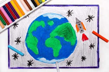 Fototapeta na wymiar Colorful drawing: Rocket in space, flying next to the planet earth