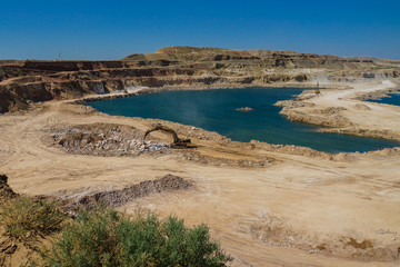 Extraction of rock salt at Lake Baskunchak open method. Excavators prepare salt blocks for loading.