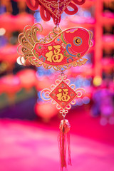 chinese symbol on decoration is hanging on with festival blur in background, the word mean luck