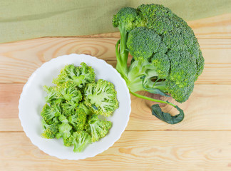 Pieces of broccoli on a dish and broccoli head
