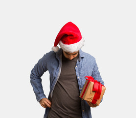 Young man wearing santa hat showing number eight