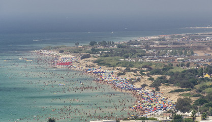 Aerial view of beautiful beach with hundreds of people having bath