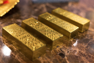 one kilo gold put on luxury marble table together in a row. closeup