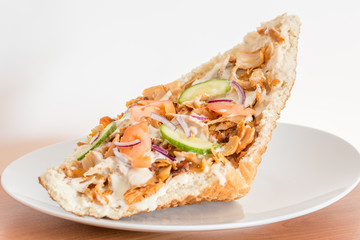 Polish fast food kebab on white plate. Kebab in pita with chicken meat.