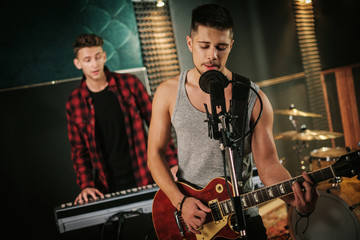 Music band having rehearsal in a studio