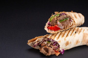 Shawarma sandwich - fresh roll of thin lavash or pita bread filled with grilled meat, mushrooms,...