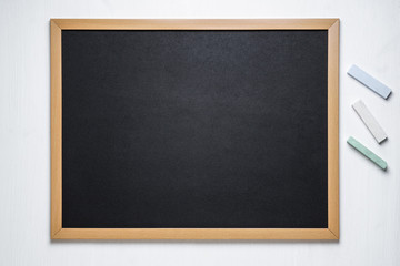 black chalk board and several colored chalk on a white  background
