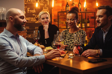 Group of friends having fun talk behind bar counter in a cafe