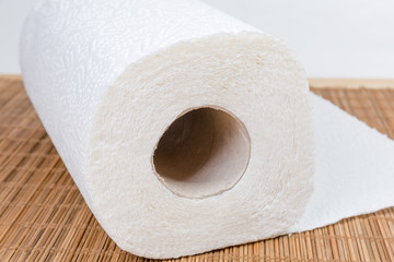 End roll of paper towels on bamboo table mat closeup