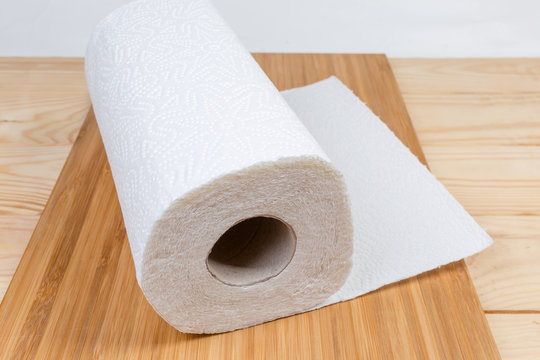 Roll of paper towels on wooden surface close-up