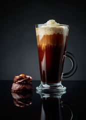 Chocolate dessert with hazelnut and coffee with cream on a black background.