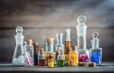 Zelfklevend Fotobehang Vintage medications in small bottles on wood desk. Old medical, chemistry and pharmacy history concept background. Retro style. © Tryfonov