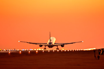 Fototapeta na wymiar 夕焼け空の滑走路から離陸する航空機　　Aircraft to take off from the sunset runway　　The most beautiful Radiates the glow of the sunset Flying happiness Aircraft image carrying good luck