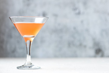 Cocktails in a martini glass on a gray background.