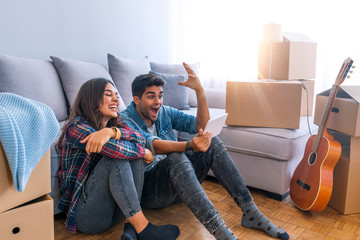 Couple moving home and buying on line with a tablet sitting on the floor