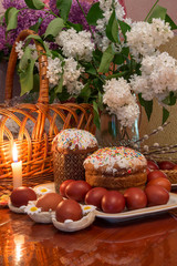 Easter composition with a traditional Russian Easter cake, Easter eggs and flowers on the table