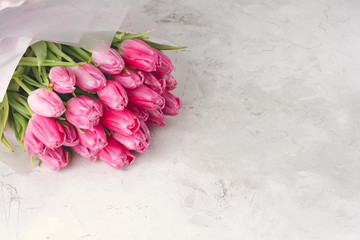 bouquet of pink tulips on a light concrete background