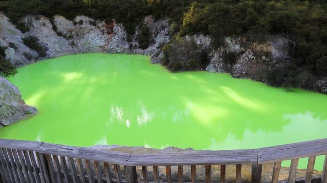 Handheld shot of sulfuric green Devils Bath pond in Waiotapu geothermal area