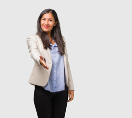 Young business indian woman reaching out to greet someone or gesturing to help, happy and excited