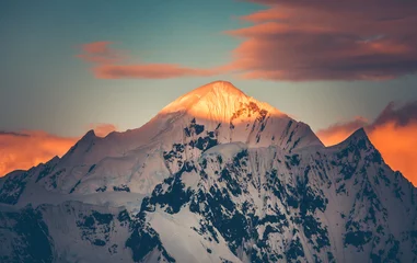 Bunter Sonnenuntergang der Bergspitze, Antarktis. Die sonnendurchflutete schneebedeckte Bergkette. Atemberaubende Polarlandschaft. Die mächtige Bergkette unter dem bewölkten Himmel des hellen Sonnenuntergangs. Erstaunliche Landschaft am Südpol. © Goinyk