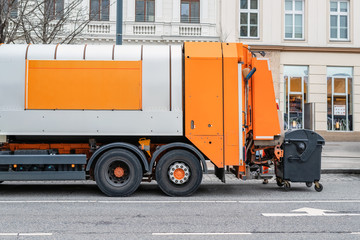 Garbage disposal lorry at city street. Waste dump truck on town road. Municipal and urban services. Waste management, disposal and recycling. Mock-up empty space. Copysapce for text