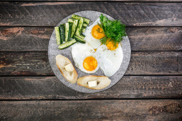 Tasty breakfast in the morning. Scrambled eggs and pickled cucumbers and salad with sauerkraut. Served with bread, butter and filter coffee. Top view