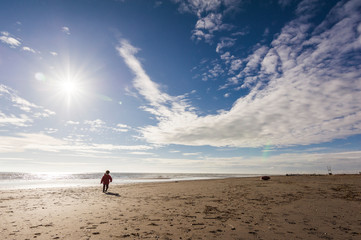 Bambino corre sulla spiaggia d'inverno