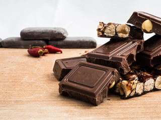 delicious chocolate and Italian hazelnut nougat, cut into pieces, for a sea of sweetness, in the background other nougats and chillies. Taken up close, with blurred background