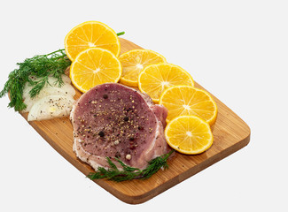 meat steak on a board with onion greens and lemon