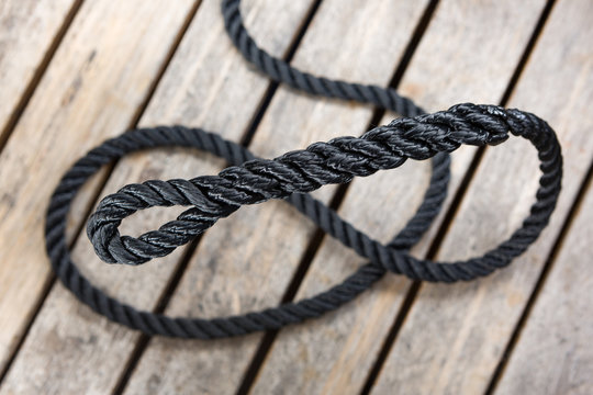 An eye splice in a piece of coiled rope on a wood background.