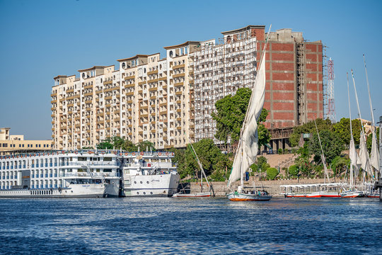 12.11.2018 Aswan, Egypt, A boat felucca sailing along a river of nilies on a sunny day against a city background