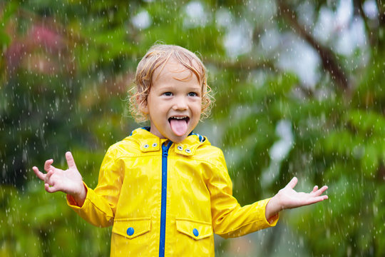 Kids play in autumn rain. Child on rainy day.