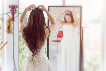 Wedding concept; the bride, the bridal hairstyle, bride in front of the mirror