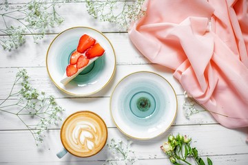 delicious cup of cappuccino with strawberry cheesecake