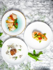 delicious dinner of salmon steak, grilled beef medallions and chicken fillet with vegetables