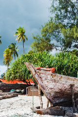 old wooden fishing boats with paddles on a beach of fishing village in Zanzibar