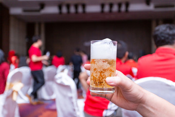 Raised beer glass at a party.