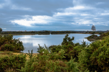 Fototapeta na wymiar Stormy clouds over lake in New Forest countryside