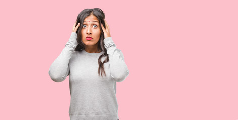 Fototapeta premium Portrait of young indian woman covering ears with hands, angry and tired of hearing some sound